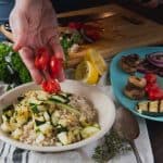 Adding tomatoes to barley salad