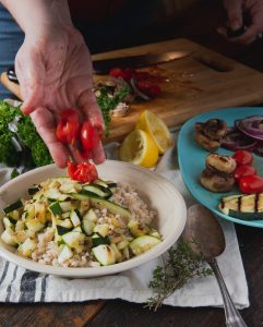 Adding tomatoes to barley salad